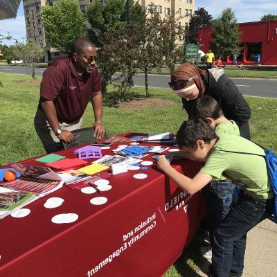 Calvin Hill talks with people in the community as they do crafts. 